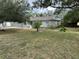 House with a large front yard, landscaping, and driveway at 8353 Forest Oaks Blvd, Spring Hill, FL 34606