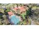 A swimming pool and patio next to a clubhouse with a red roof and manicured grounds at 10441 Garda Dr, Trinity, FL 34655
