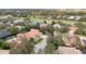 A high-angle view of homes surrounded by trees and a green golf course in the background at 10441 Garda Dr, Trinity, FL 34655