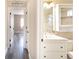 Bright bathroom view with a vanity and toilet, leading to a bedroom with gray wood-look floors at 10441 Garda Dr, Trinity, FL 34655