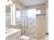 Cozy bathroom with a vanity, toilet, and shower with decorative shower curtain at 10441 Garda Dr, Trinity, FL 34655