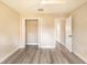 Bright bedroom featuring gray wood-look floors, closet and two doorways at 10441 Garda Dr, Trinity, FL 34655