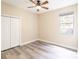 Comfortable bedroom with gray wood-look flooring, closet, and a large window at 10441 Garda Dr, Trinity, FL 34655