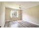Cozy bedroom featuring hardwood floors, a ceiling fan, and a window offering natural light at 10441 Garda Dr, Trinity, FL 34655