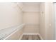 A walk-in closet with wire shelving is shown with a wood-look floor and is well-lit at 10441 Garda Dr, Trinity, FL 34655