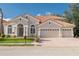 Charming home featuring a three-car garage, beautiful red tile roof, and lush green landscaping at 10441 Garda Dr, Trinity, FL 34655