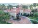 Aerial view of luxurious home featuring a brick driveway, tile roof, and lush landscaping at 10441 Garda Dr, Trinity, FL 34655