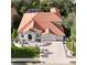 Aerial view of a lovely two-story home boasting an orange tile roof, paver driveway, and a meticulously landscaped yard at 10441 Garda Dr, Trinity, FL 34655