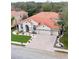 A stunning two story home showcasing an orange tile roof, paver driveway and beautifully landscaped yard at 10441 Garda Dr, Trinity, FL 34655