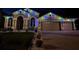 Beautiful front exterior elevation of a home at night with Christmas lights outlining the roof and windows at 10441 Garda Dr, Trinity, FL 34655