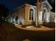 A lovely home at night with exterior lighting and landscape lighting surrounding the exterior at 10441 Garda Dr, Trinity, FL 34655