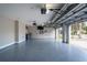 Large garage with epoxy flooring, interior access, and motorized door openers and ceiling fan at 10441 Garda Dr, Trinity, FL 34655