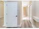 Hallway with light walls and tile, and doorway leading to a room with wood-look floors at 10441 Garda Dr, Trinity, FL 34655