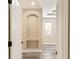 Neutral hallway with arched niche and decorative trim, leading to light-filled room with wood-look floors at 10441 Garda Dr, Trinity, FL 34655