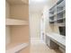 Hallway featuring an adjacent open shelving area and a built-in desk with upper shelving at 10441 Garda Dr, Trinity, FL 34655