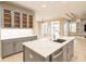 Kitchen island boasts stainless steel sink and sleek cabinetry, open floor plan to living area at 10441 Garda Dr, Trinity, FL 34655