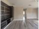 Large living room featuring gray wood-look floors and a built-in entertainment center at 10441 Garda Dr, Trinity, FL 34655