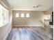 Open living area featuring gray wood-look floors, staircase, and unique arched windows at 10441 Garda Dr, Trinity, FL 34655