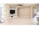Living room showcasing a modern entertainment center, tray ceiling, and access to outdoor space at 10441 Garda Dr, Trinity, FL 34655