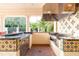 Outdoor kitchen featuring tile accents, a grill, and a sink under a covered area at 10441 Garda Dr, Trinity, FL 34655