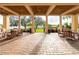 Spacious outdoor patio with brick floor, comfortable seating, and views of lush greenery at 10441 Garda Dr, Trinity, FL 34655
