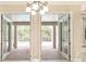 View of the covered patio leading to the pool with brick pavers and a chandelier at 10441 Garda Dr, Trinity, FL 34655