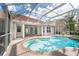 Inviting pool with steps for easy access, surrounded by brick pavers, and an enclosed patio at 10441 Garda Dr, Trinity, FL 34655