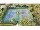 Aerial view of well-maintained tennis and pickle ball courts surrounded by lush landscaping at 10441 Garda Dr, Trinity, FL 34655