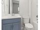 Small bathroom with a blue vanity, white toilet, and bathtub at 10693 Calluna Dr, Odessa, FL 33556