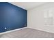 Bright bedroom with gray carpeting, blue accent wall, and white plantation shutters at 10693 Calluna Dr, Odessa, FL 33556