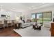 Open-concept living room and kitchen with hardwood floors and large windows at 10693 Calluna Dr, Odessa, FL 33556