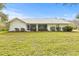 Single-story home with a gray roof, white exterior, and screened porch at 12213 Mango Ct, Spring Hill, FL 34609