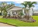 House with a porch, landscaping and palm trees at 203 S Spring Blvd, Tarpon Springs, FL 34689