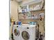 Laundry room with washer, dryer, and shelving units at 2533 Wood Pointe Dr, Holiday, FL 34691