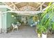 Inviting covered patio with seating area, lush tropical plants, and access to the home at 2697 Royal Ridge Dr, Spring Hill, FL 34606