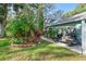 Landscaped side yard with golf cart and lush tropical plants at 2697 Royal Ridge Dr, Spring Hill, FL 34606