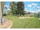 Landscaped backyard with lush lawn, mature trees, and privacy fence at 3527 Conifer Loop, Spring Hill, FL 34609