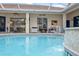 Inviting pool area with covered patio, wicker furniture, and spa at 3527 Conifer Loop, Spring Hill, FL 34609