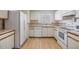 White kitchen with ample cabinetry and a view into the dining area at 4222 Northampton Dr, New Port Richey, FL 34653
