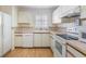 Bright kitchen with white appliances and wood-look flooring at 4222 Northampton Dr, New Port Richey, FL 34653
