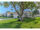 One-story home nestled under a large tree, showcasing a well-maintained yard at 480 Fort Mill Ln, Spring Hill, FL 34609