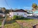 White house with brown trim, small yard, and chain link fence at 6176 Island Dr, Weeki Wachee, FL 34607