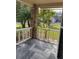 Covered porch with gray tile flooring, brick column, and view of the front yard at 6429 Remus Dr, New Port Richey, FL 34653