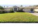 Single-story home with attached garage and landscaped lawn at 10516 Moshie Ln, San Antonio, FL 33576