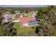 Aerial view of a home with a private pool and fenced backyard surrounded by trees at 12224 Mango Ct, Spring Hill, FL 34609