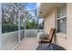 Cozy screened porch with seating and a small grill at 1454 Overland Dr, Spring Hill, FL 34608