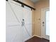 Inviting entryway with white barn doors and wood flooring at 15724 Peruvian Lily Ct, Brooksville, FL 34604