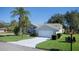 House exterior with a white garage door and palm trees at 3126 Double Eagle Ct, Spring Hill, FL 34606