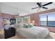 Main bedroom with king-size bed, ceiling fan, and water views at 4620 Bay Blvd # 1148, Port Richey, FL 34668