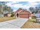 Front view of a one-story house with a brown exterior and a two-car garage at 9612 Southern Charm Cir, Brooksville, FL 34613